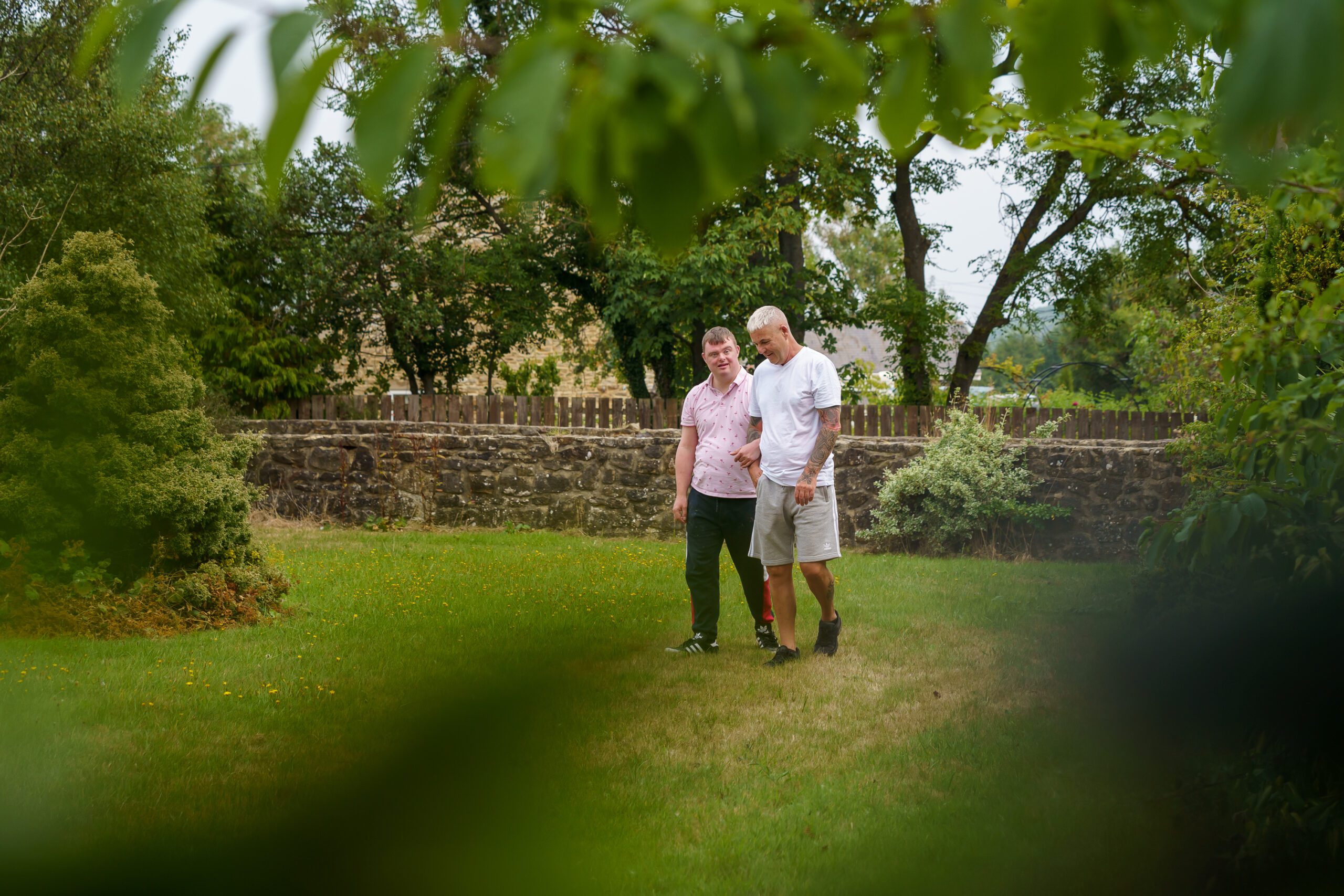 A man and his supporter worker in a garden at the farm