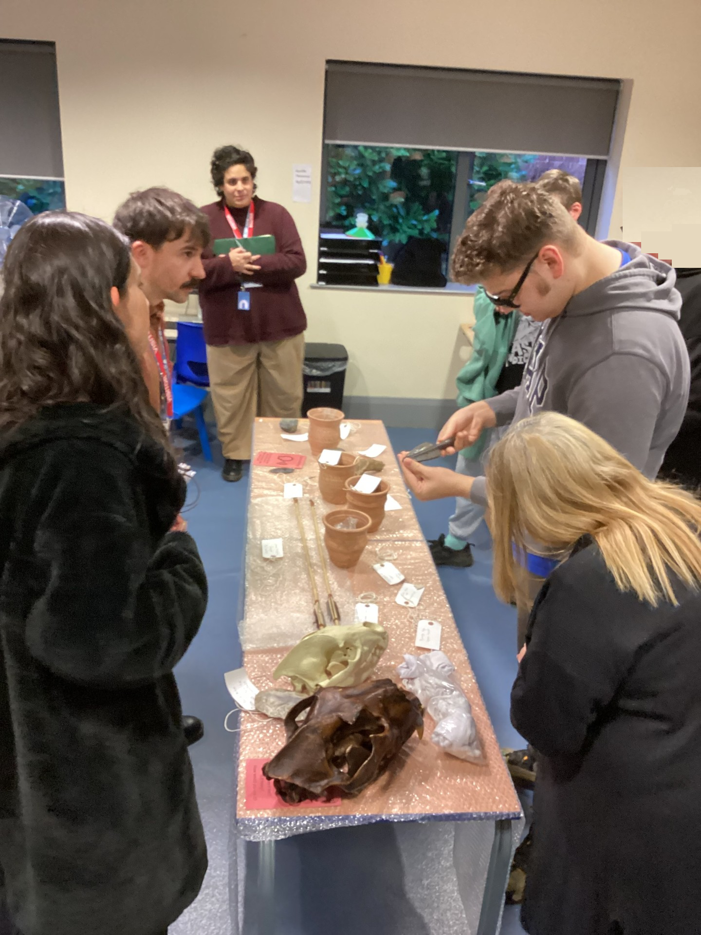 Pupils looking at museum artefacts laid on a table